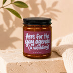 Amber jar candle with label text "Here for the gay agenda (a wedding)".