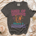 "Maid of Honour Needs a Mimosa" t-shirt with champagne bottle and glass design.