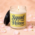 Glass candle with lit wick and "Squad of Honor Vowed" text on yellow label.
