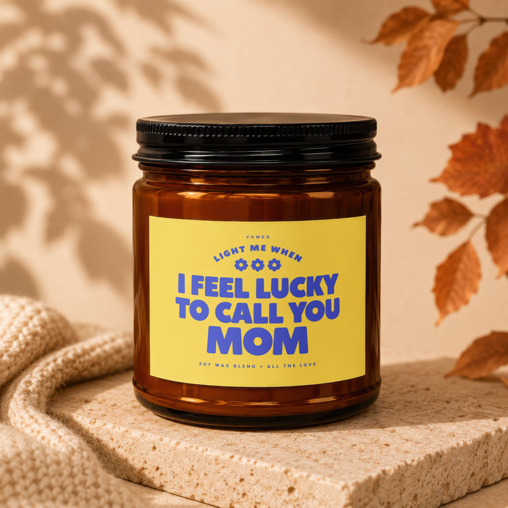 Brown amber jar candle with yellow label reading "I FEEL LUCKY TO CALL YOU MOM."