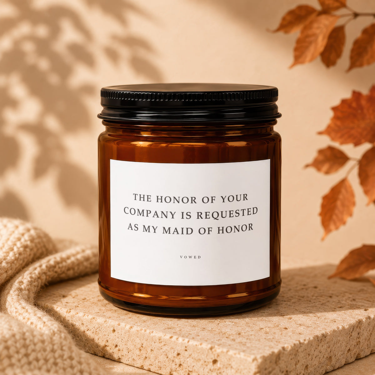 Amber candle with a white label that reads "The honor of your company is requested as my maid of honor."