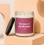 Glass candle with "the man of my dreams" text on label, lid off.