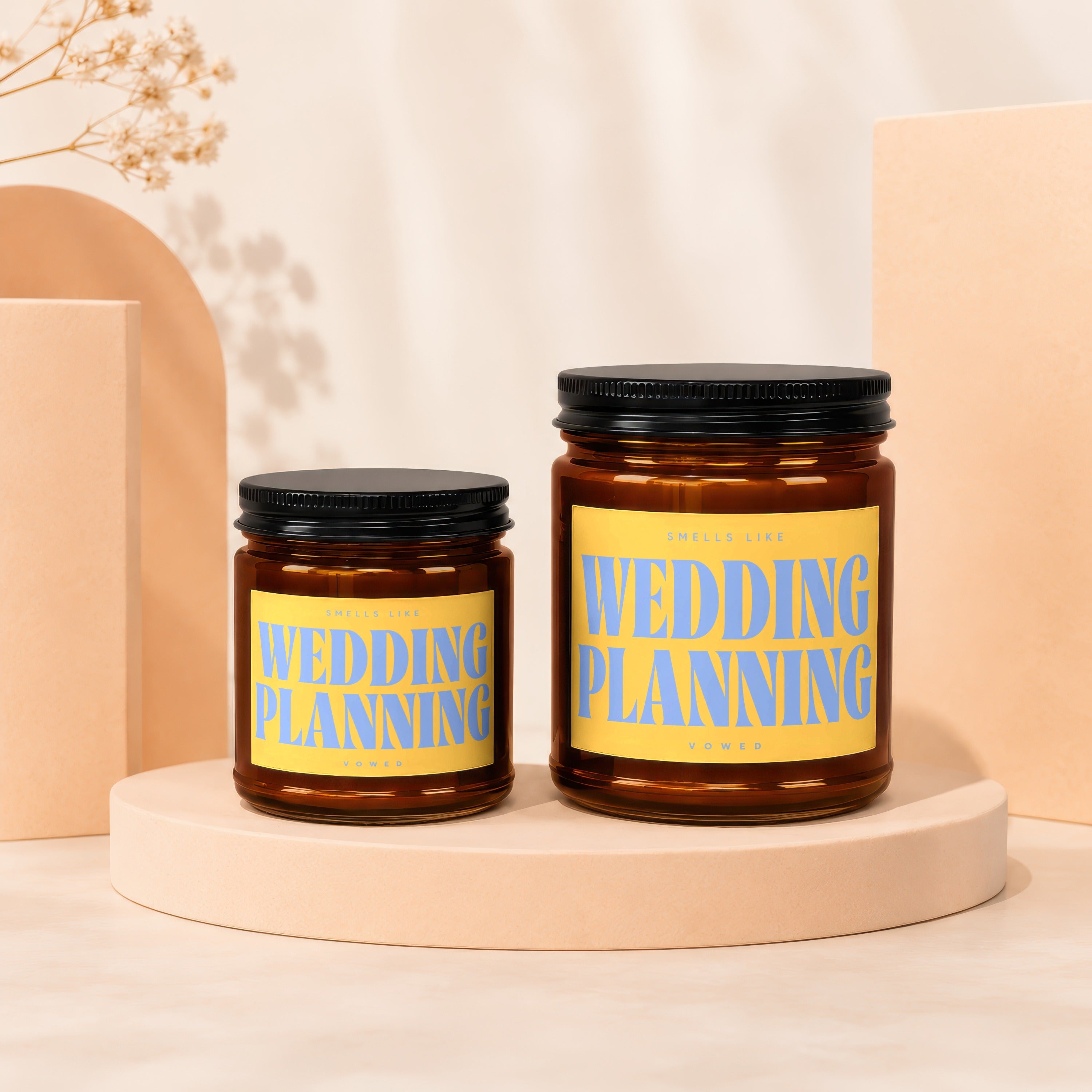 Two amber glass candles with black lids, labeled Wedding Planning.