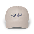 A light beige baseball cap with the blue embroidered text Nash Bash centered on the front.
