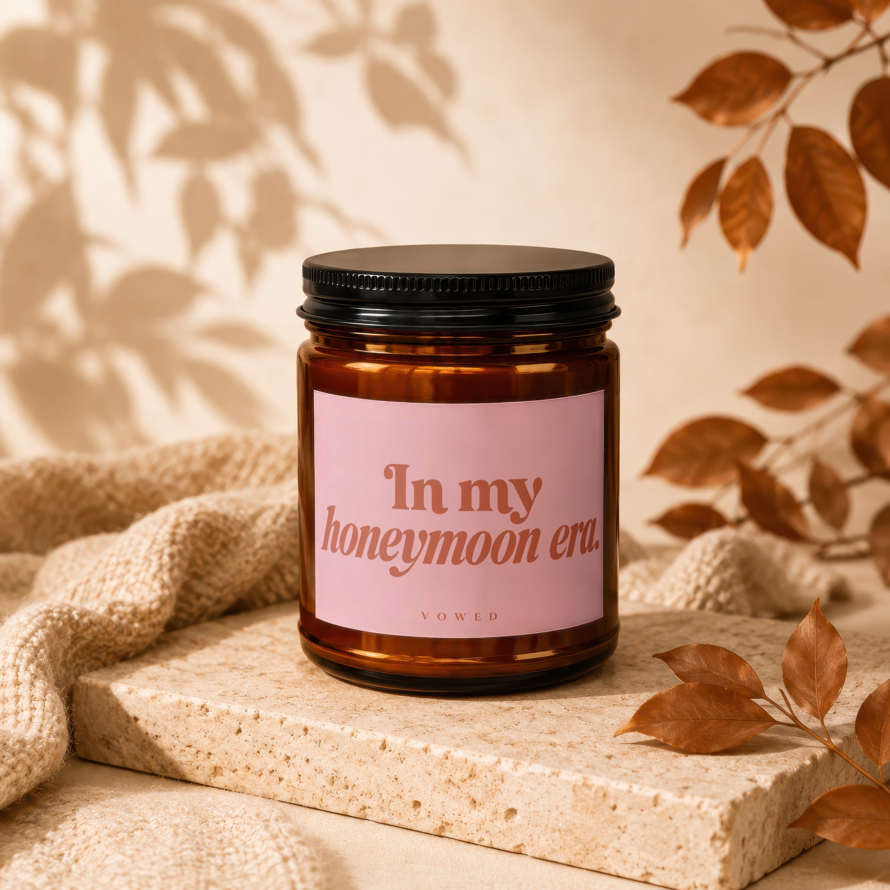 Amber candle with pink label reading "In my honeymoon era."