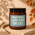 Amber candle with a blue label that reads "Marriage Looks Good on Us Vowed".