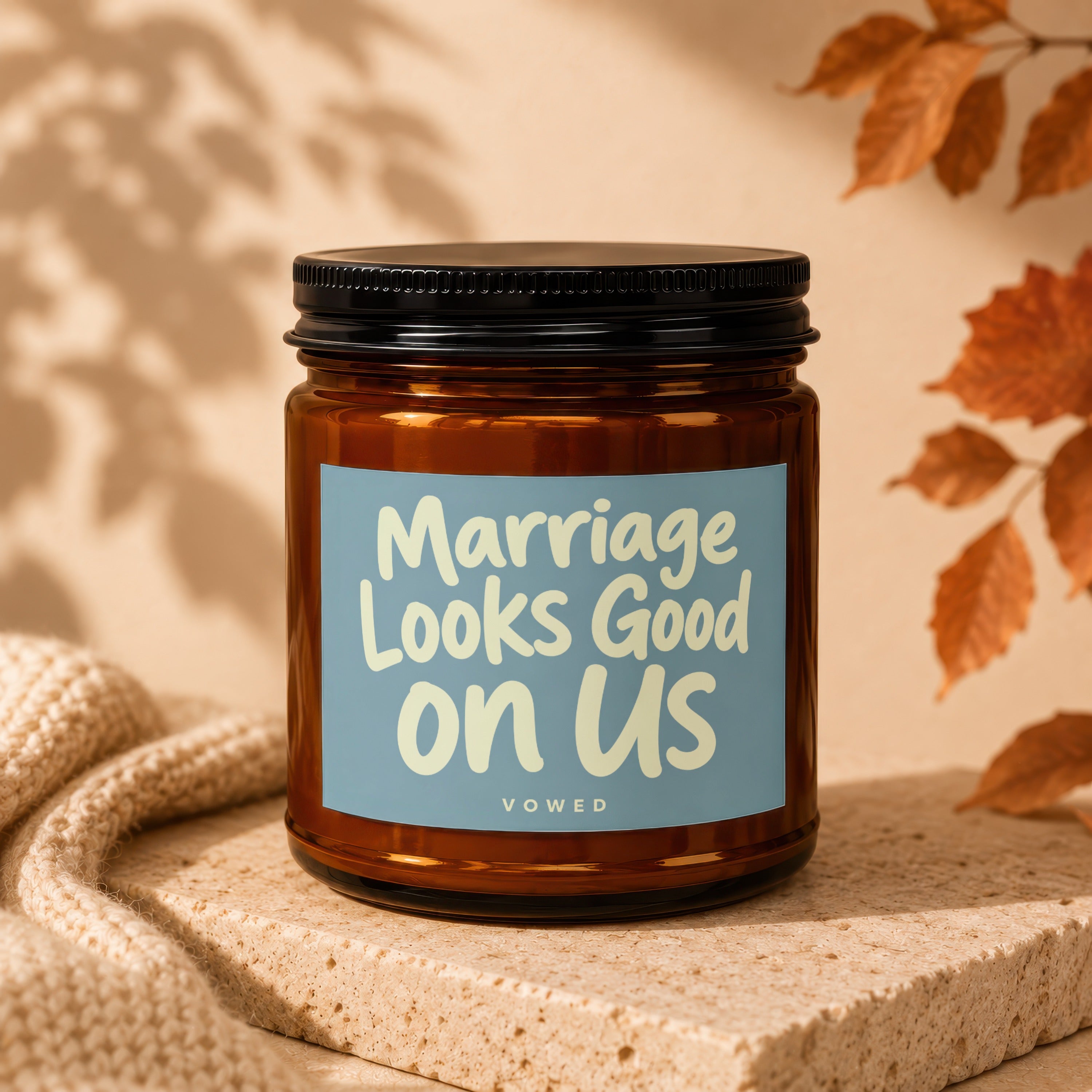 Amber candle with a blue label that reads "Marriage Looks Good on Us Vowed".