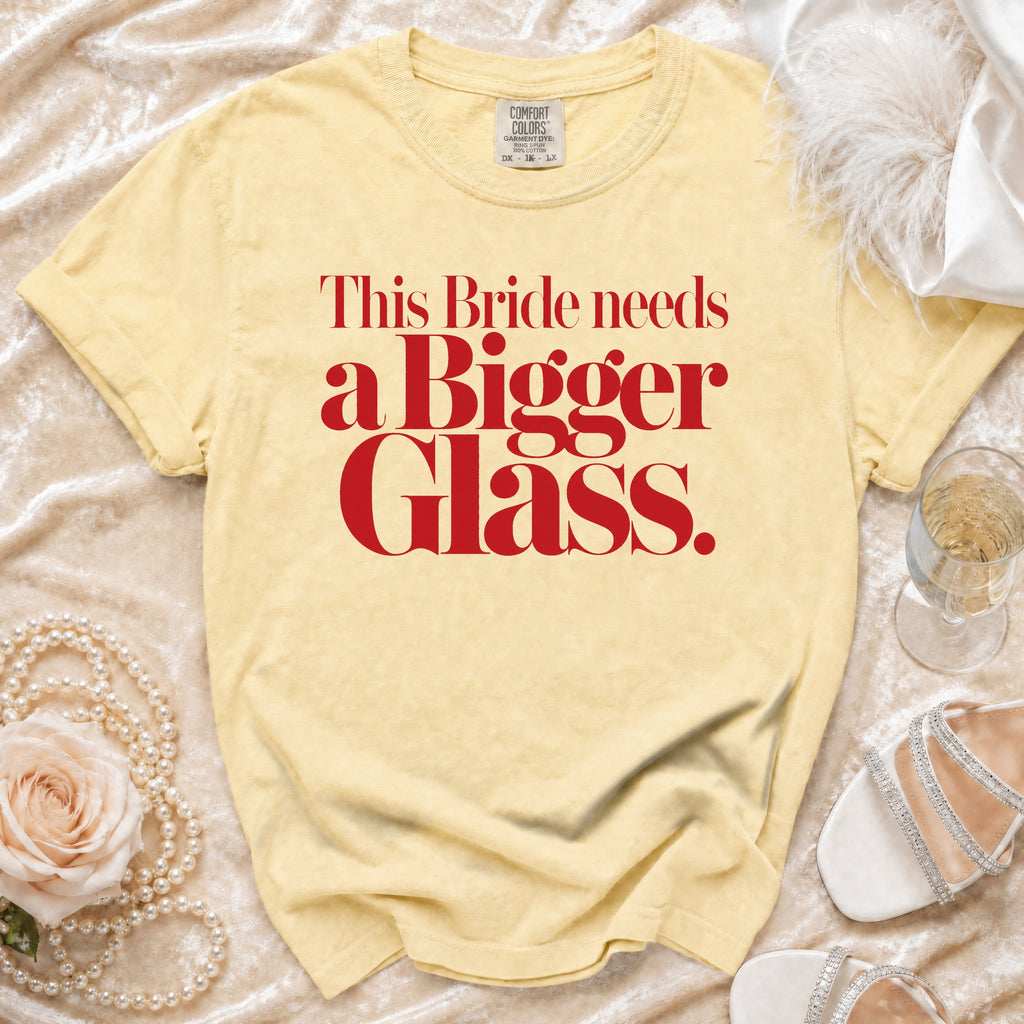 Yellow t-shirt with red text that reads "This Bride needs a Bigger Glass."