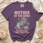 Purple t-shirt with "Mother of the Bride Raising Hell Not Just Her" graphic.