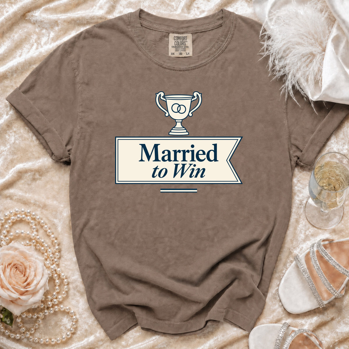 Brown t-shirt with "Married to Win" text and wedding rings in a trophy design.