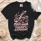 Black t-shirt with "Maid of Honor Because Therapy is Expensive" text and champagne graphics.