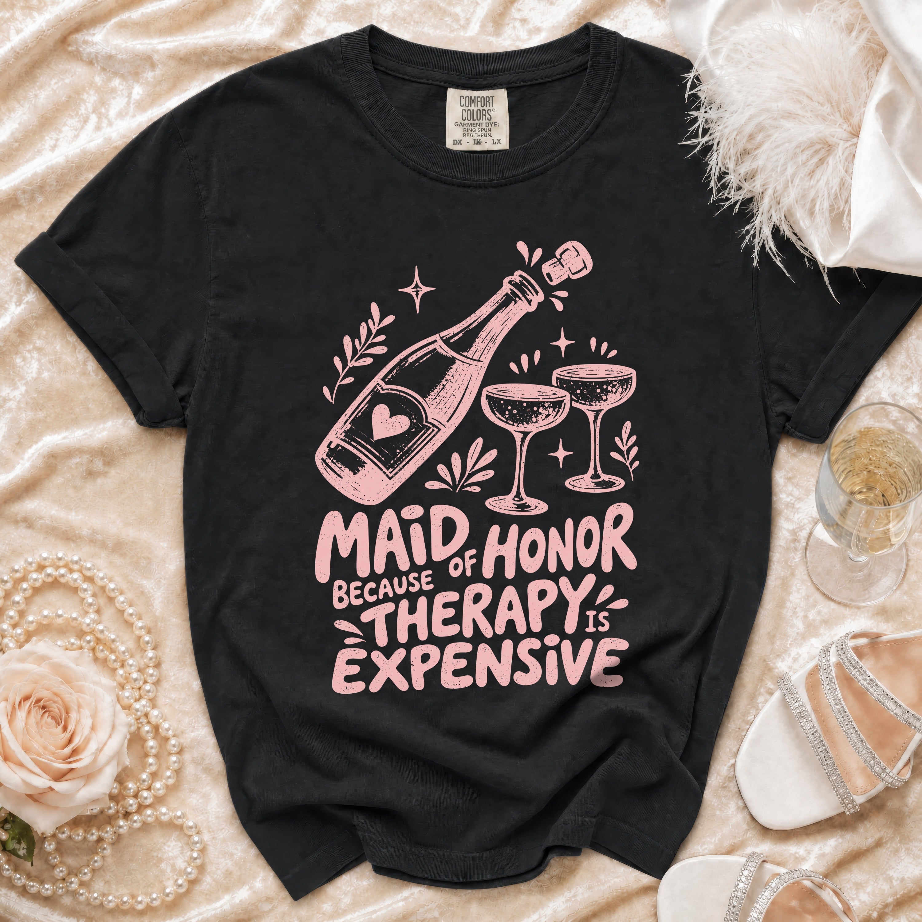 Black t-shirt with "Maid of Honor Because Therapy is Expensive" text and champagne graphics.