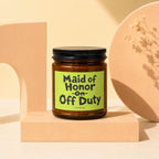 Amber glass candle with black lid featuring "Maid of Honor on Off Duty" text.