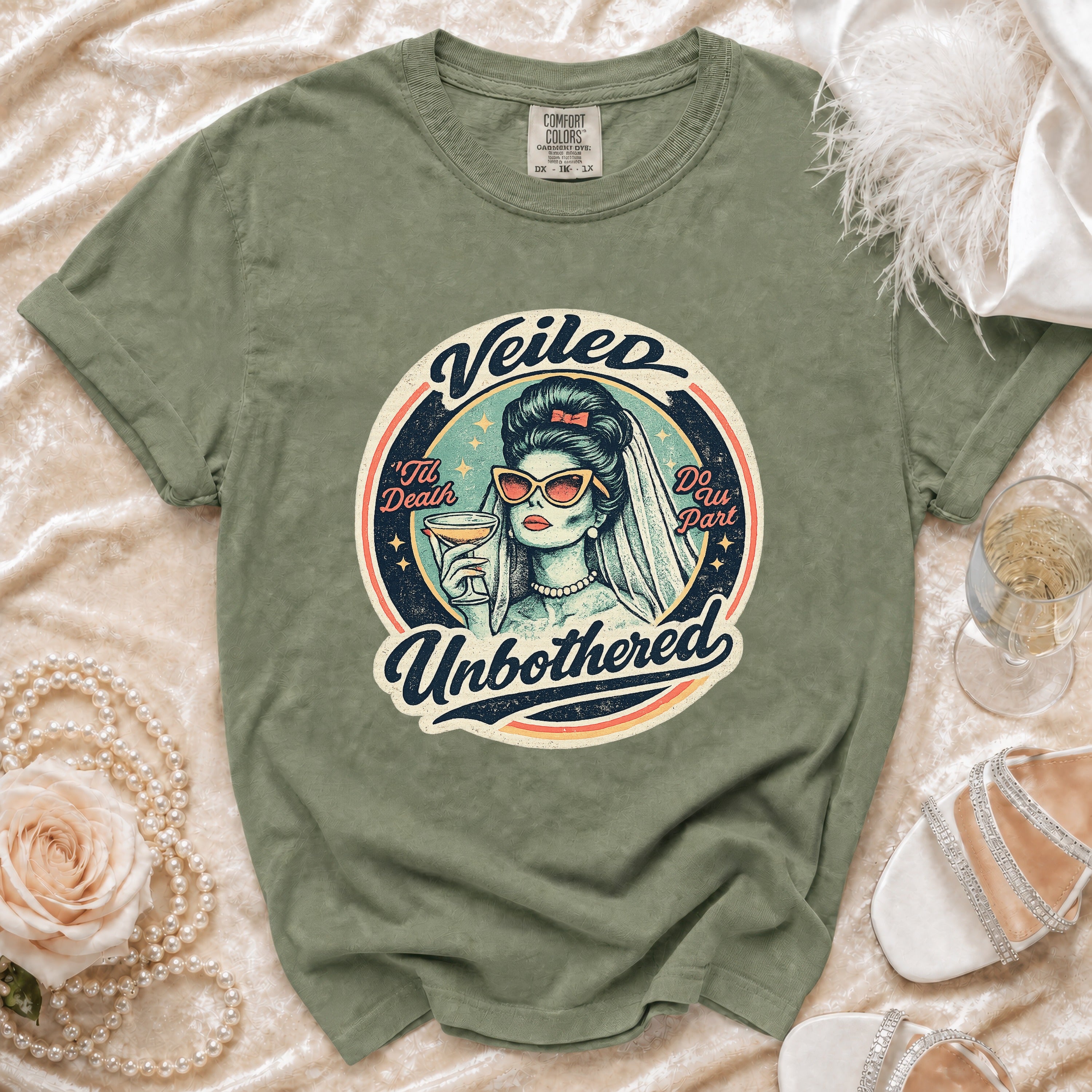 Green t-shirt with "Veiled Unbothered" graphic featuring a bride holding a drink.