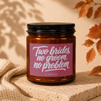 Amber candle with label reading "Two brides, no groom, no problem."