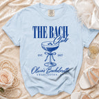 Light blue t-shirt with "The Bach Club Est. 2027 Olivia's Bachelorette Charleston SC" text.
