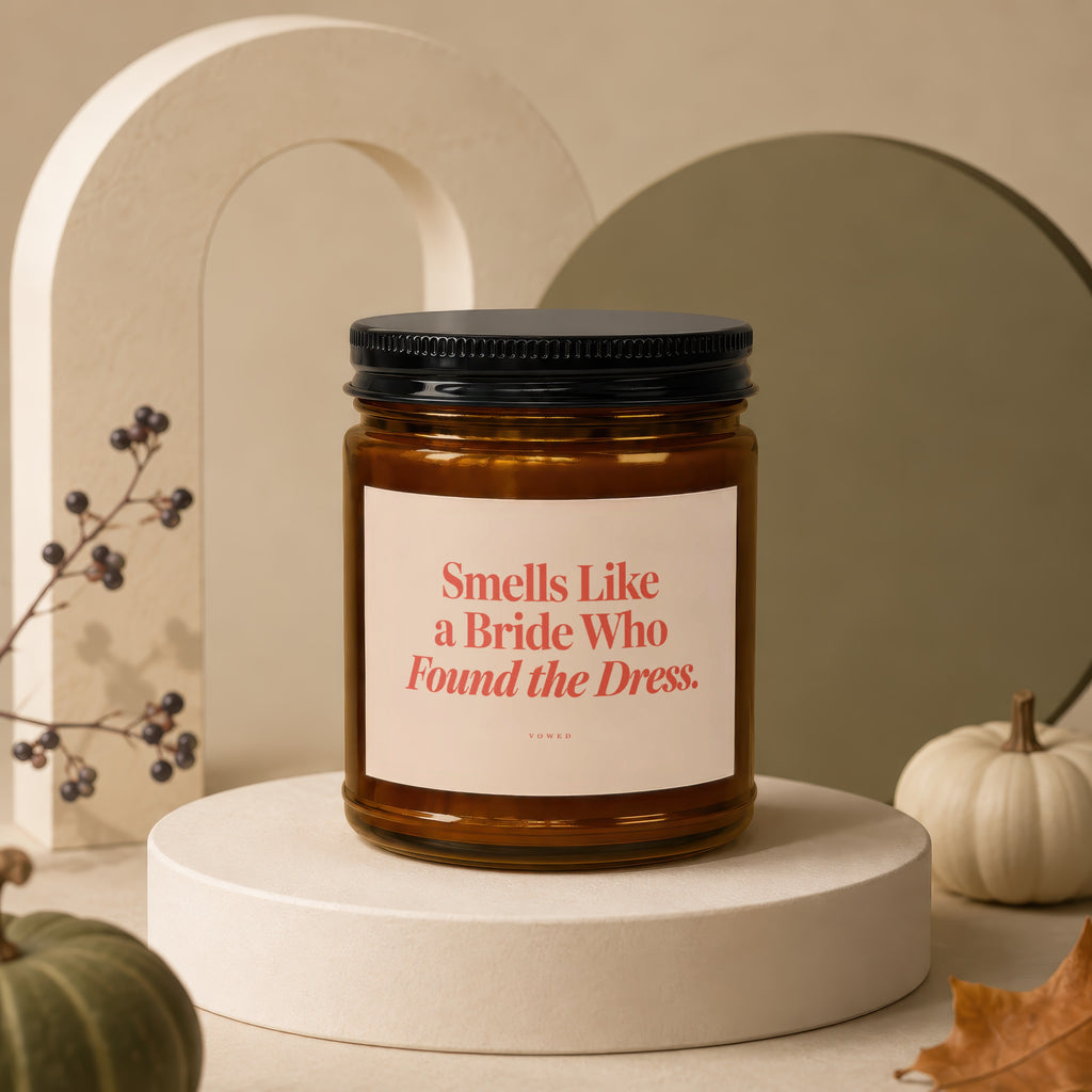 Amber jar candle with black lid and label reading "Smells Like a Bride Who Found the Dress."