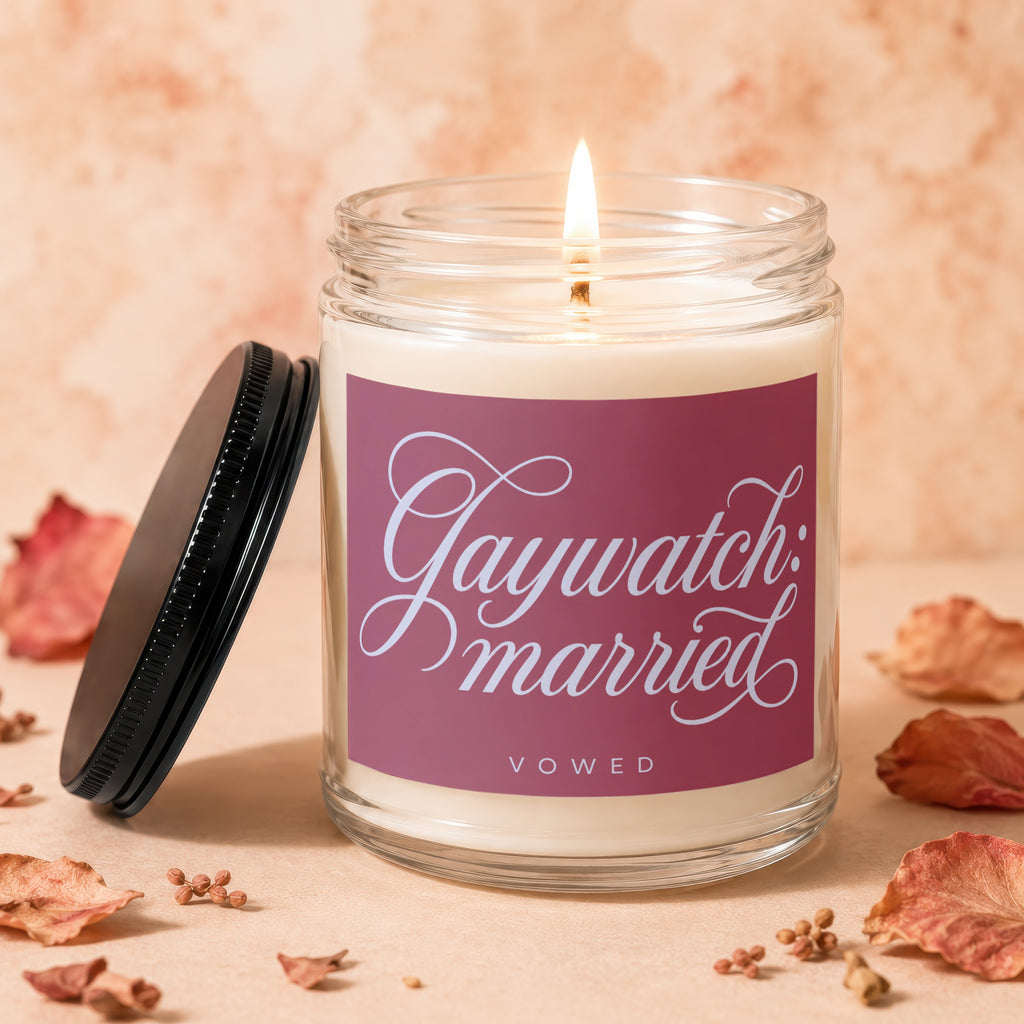 Glass candle with burning wick, lid ajar, labeled "Gaywatch: married VOWED".