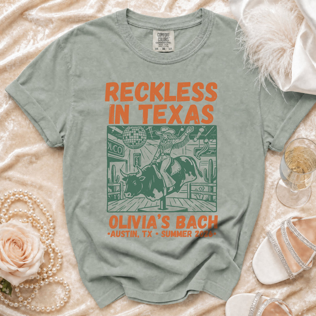 T-shirt graphic featuring a bull rider with "Reckless in Texas" and "Olivia's Bach" text.