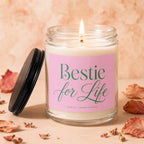 Glass jar candle with a lit wick and a pink label reading "Bestie for Life."