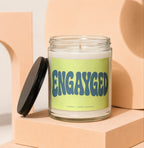 Glass jar candle with "ENGAYGED" text on a light green label.