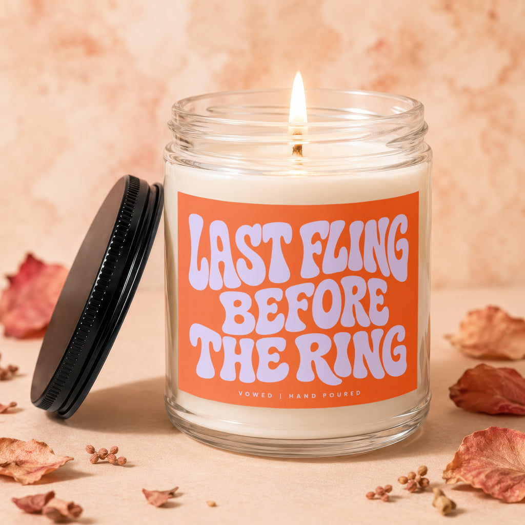 Burning candle with orange label reading "LAST FLING BEFORE THE RING"