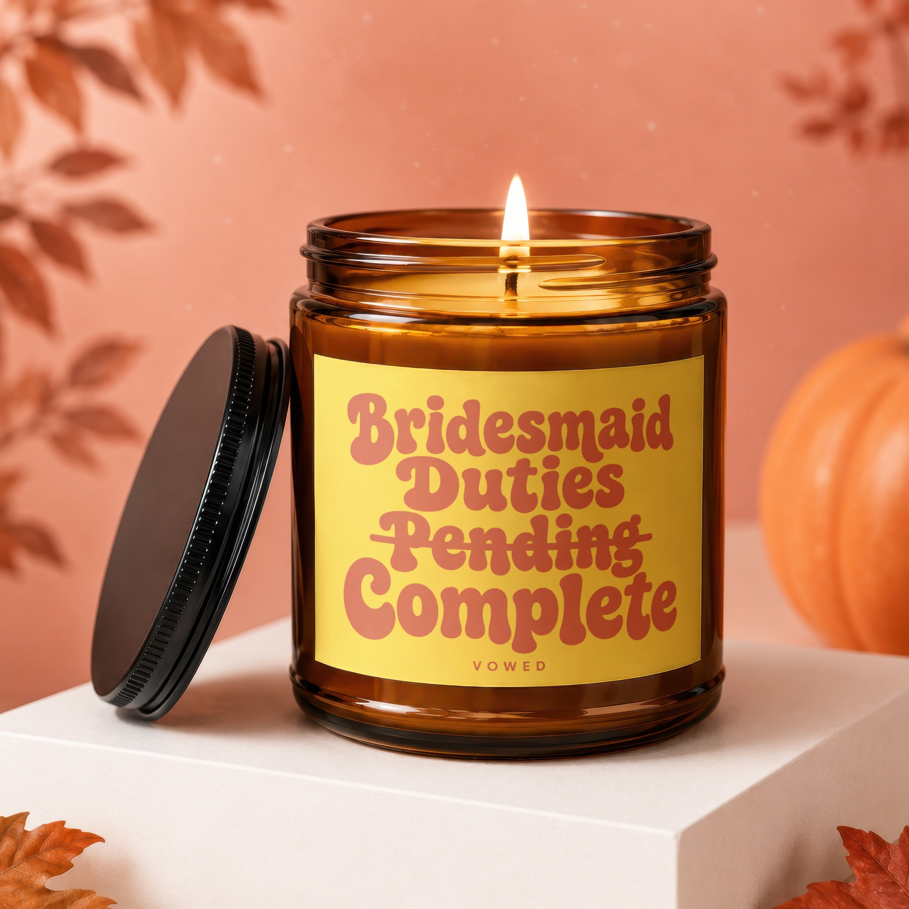 Amber jar candle with lit wick and "Bridesmaid Duties Pending Complete" text.