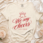 Cream t-shirt with red text "We say Cheers THE CREW" and champagne glasses.