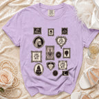 Purple t-shirt with framed gothic illustrations including skulls, cake, and "Love at First Bite" text.