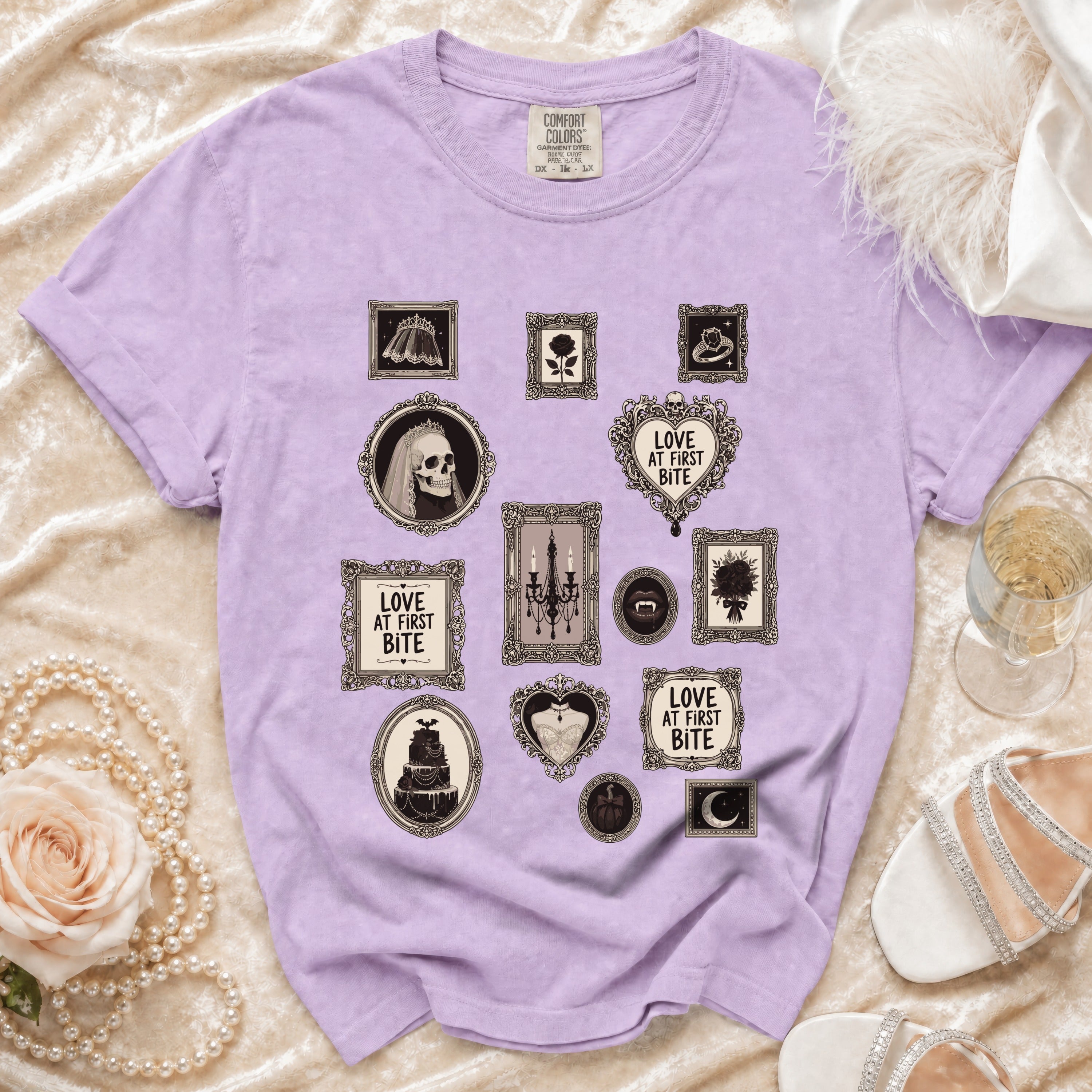 Purple t-shirt with framed gothic illustrations including skulls, cake, and "Love at First Bite" text.