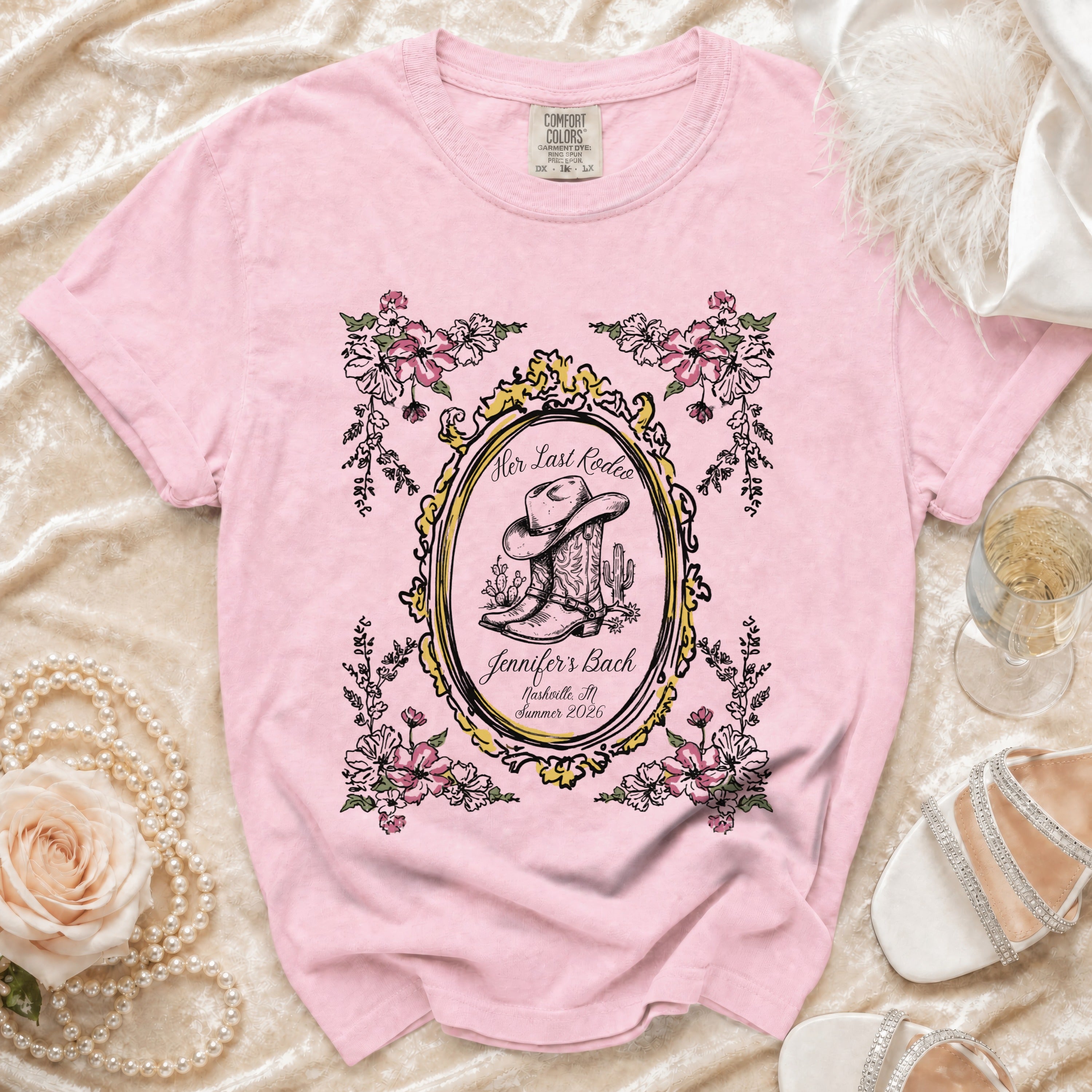 Pink t-shirt with cowboy boot, hat, and flowers; "Her Last Rodeo" text.
