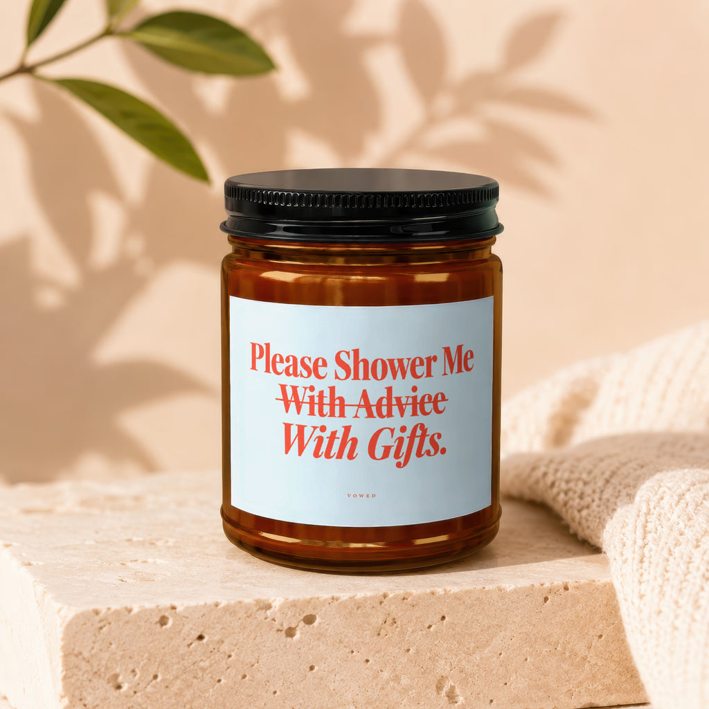 Amber jar candle with a label that reads "Please Shower Me With Advice With Gifts."