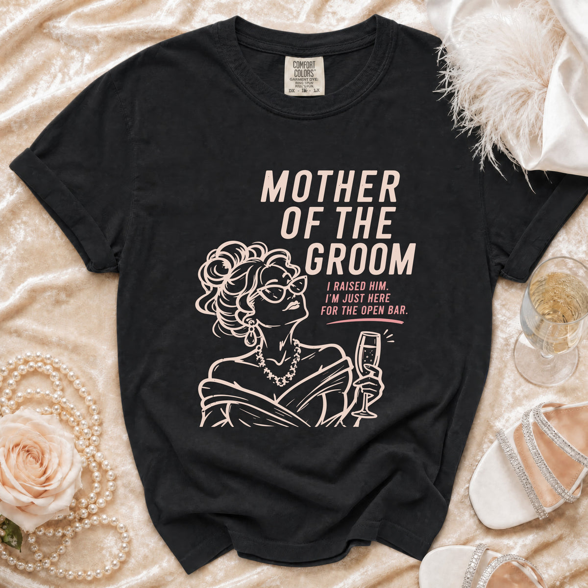 Black t-shirt with "Mother of the Groom" and humorous quote, featuring a sketched woman with champagne.