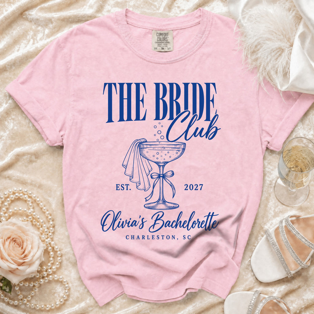 Pink t-shirt with "The Bride Club" text and bachelorette design.
