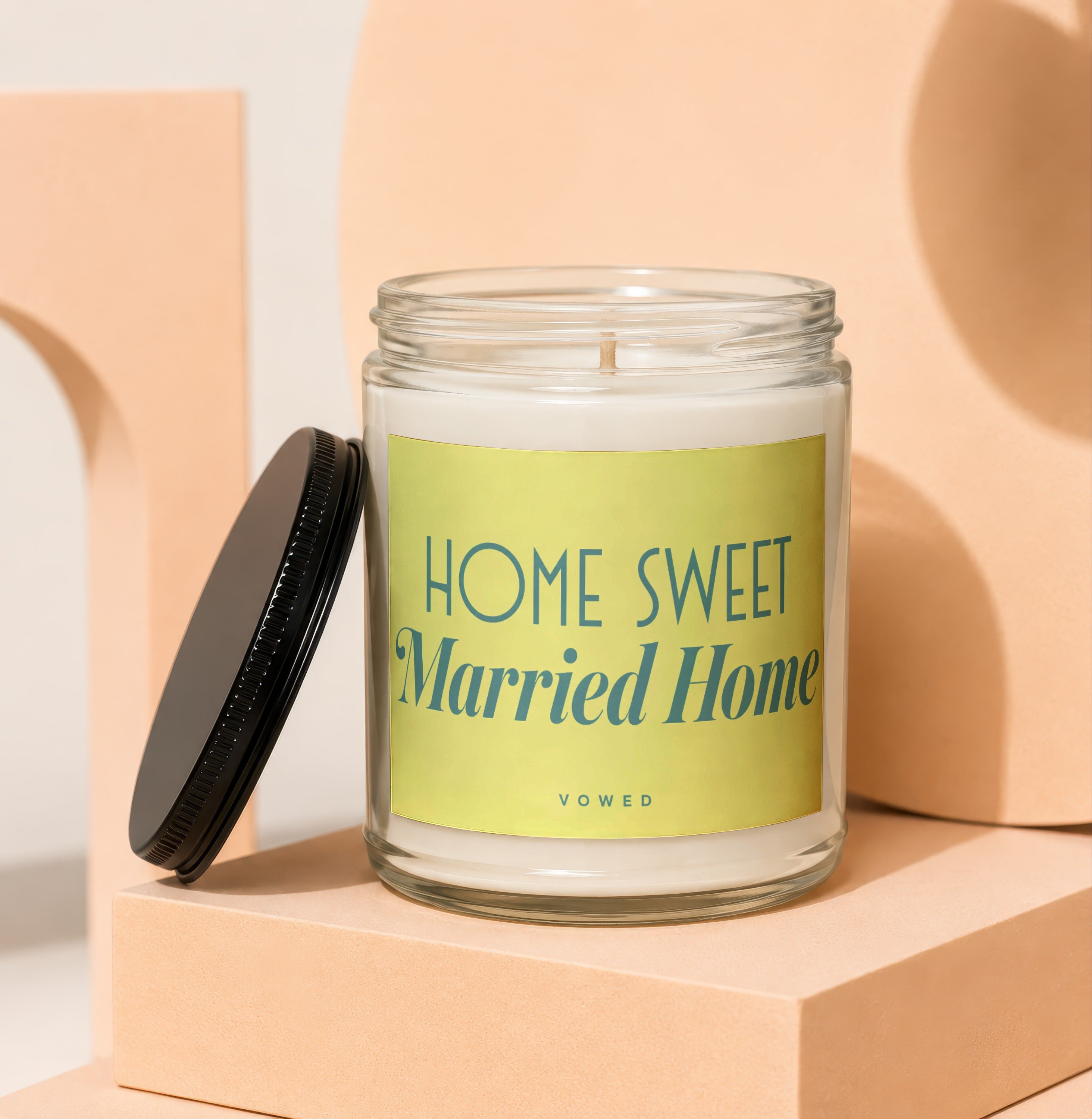 Glass jar candle with yellow label reading "HOME SWEET Married Home" and "VOWED".