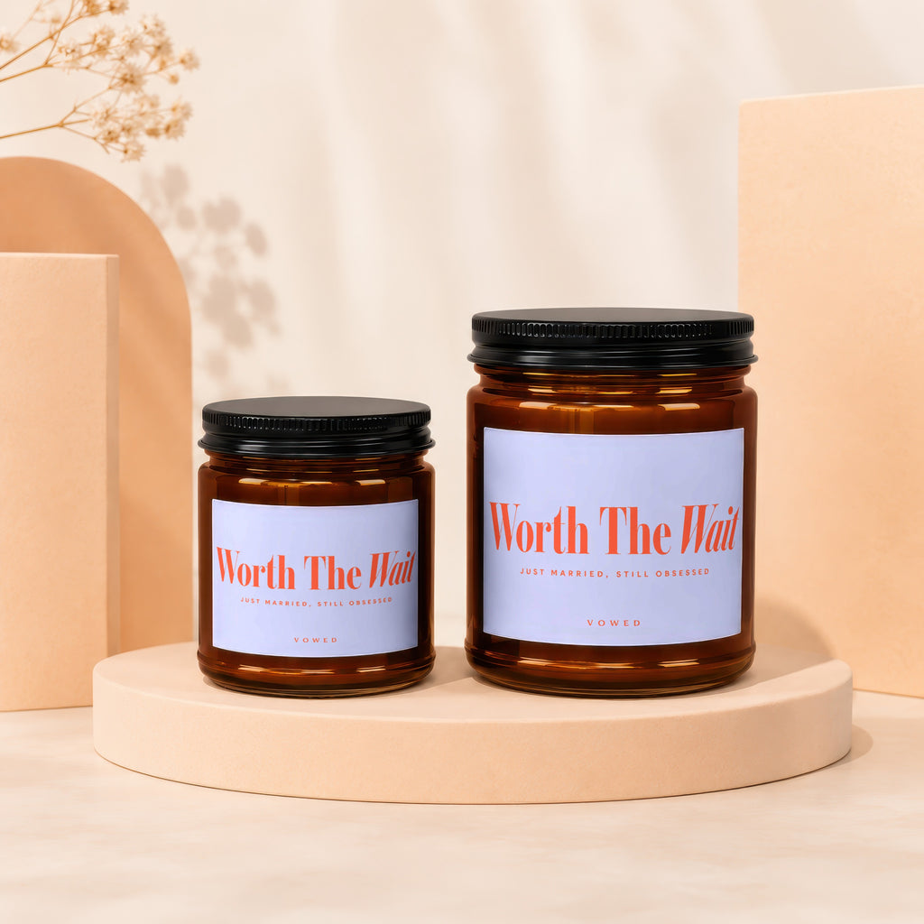 Two amber glass candles with black lids and "Worth The Wait" labels.