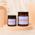Two amber glass candles with black lids and "Worth The Wait" labels.