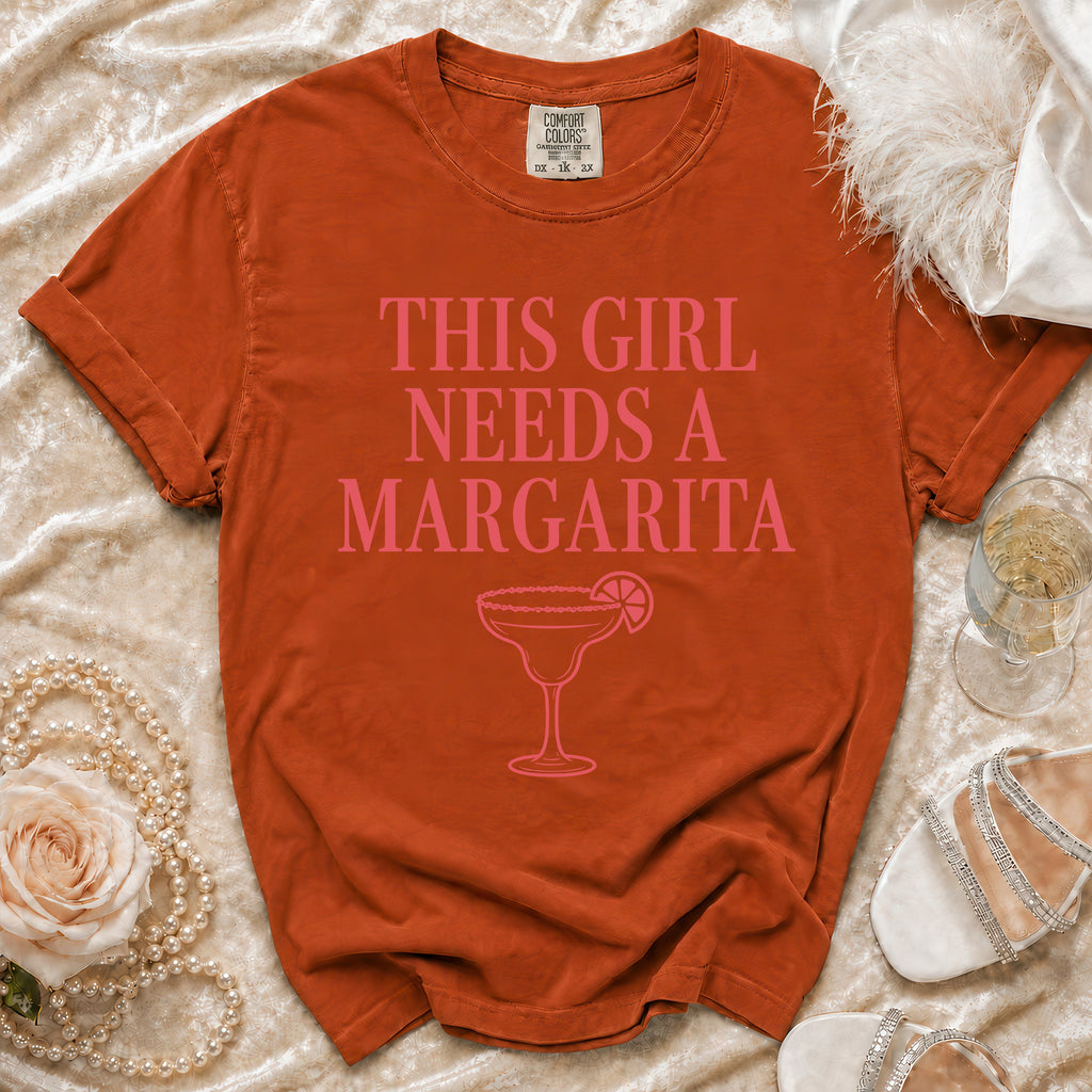 Orange t-shirt with pink text "THIS GIRL NEEDS A MARGARITA" and a margarita glass.