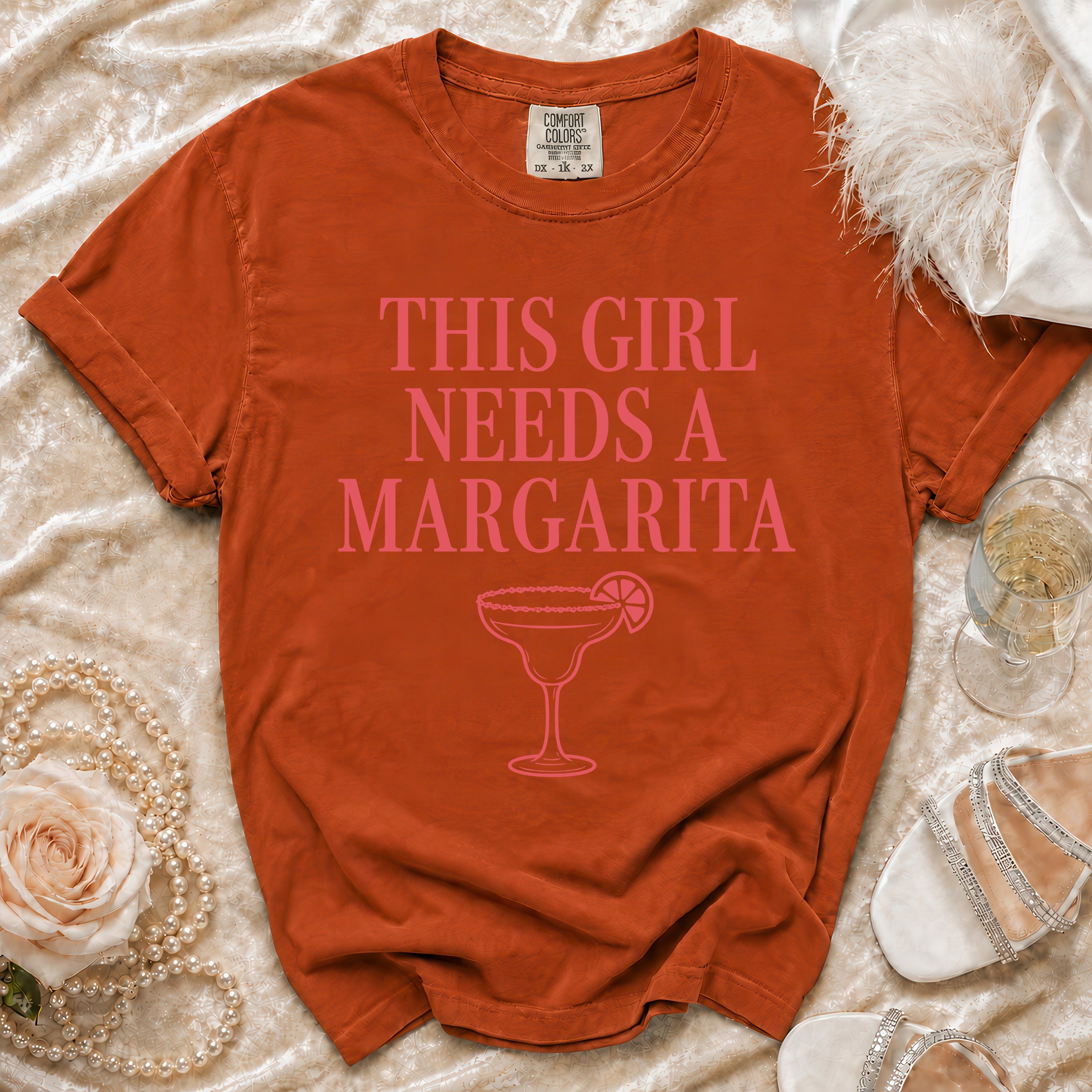 Orange t-shirt with pink text "THIS GIRL NEEDS A MARGARITA" and a margarita glass.