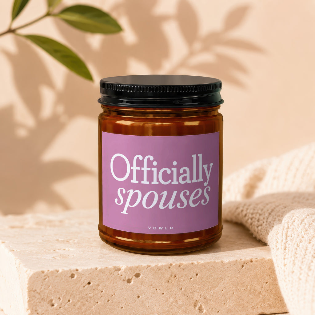 Amber candle with "Officially spouses VOWED" on a pink label.