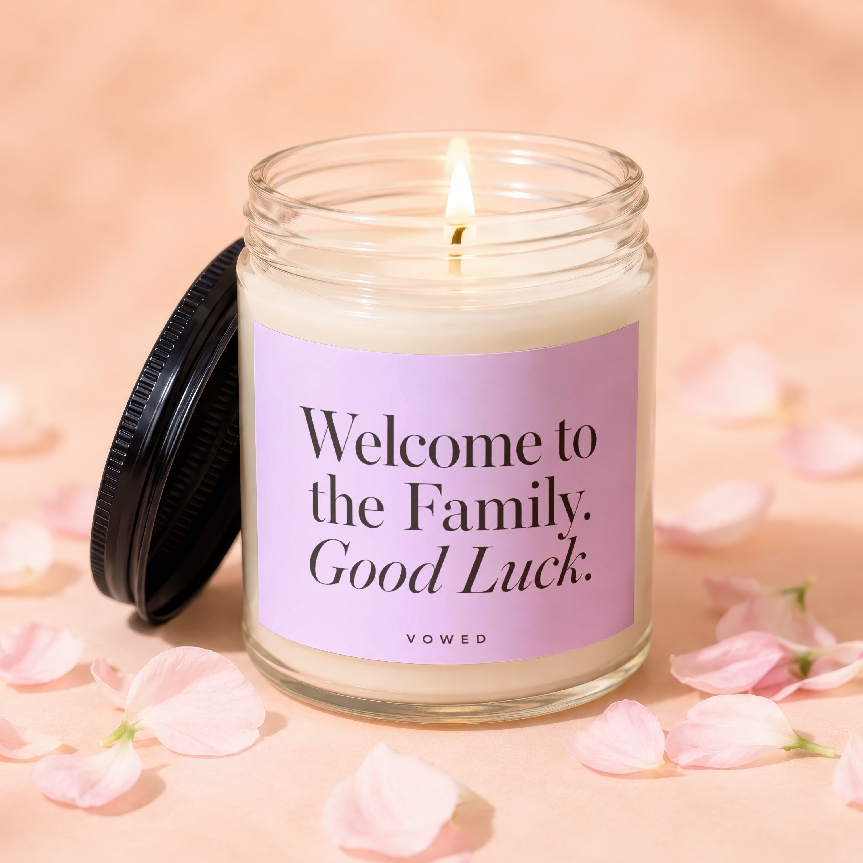 Lit candle with "Welcome to the Family. Good Luck." text on label.