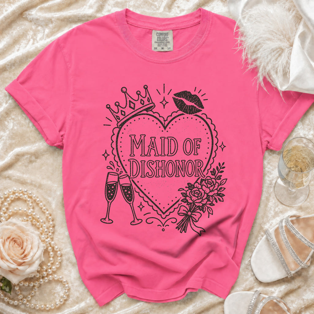 Pink t-shirt with "Maid of Dishonor" text, crown, lipstick, and champagne glasses graphic.