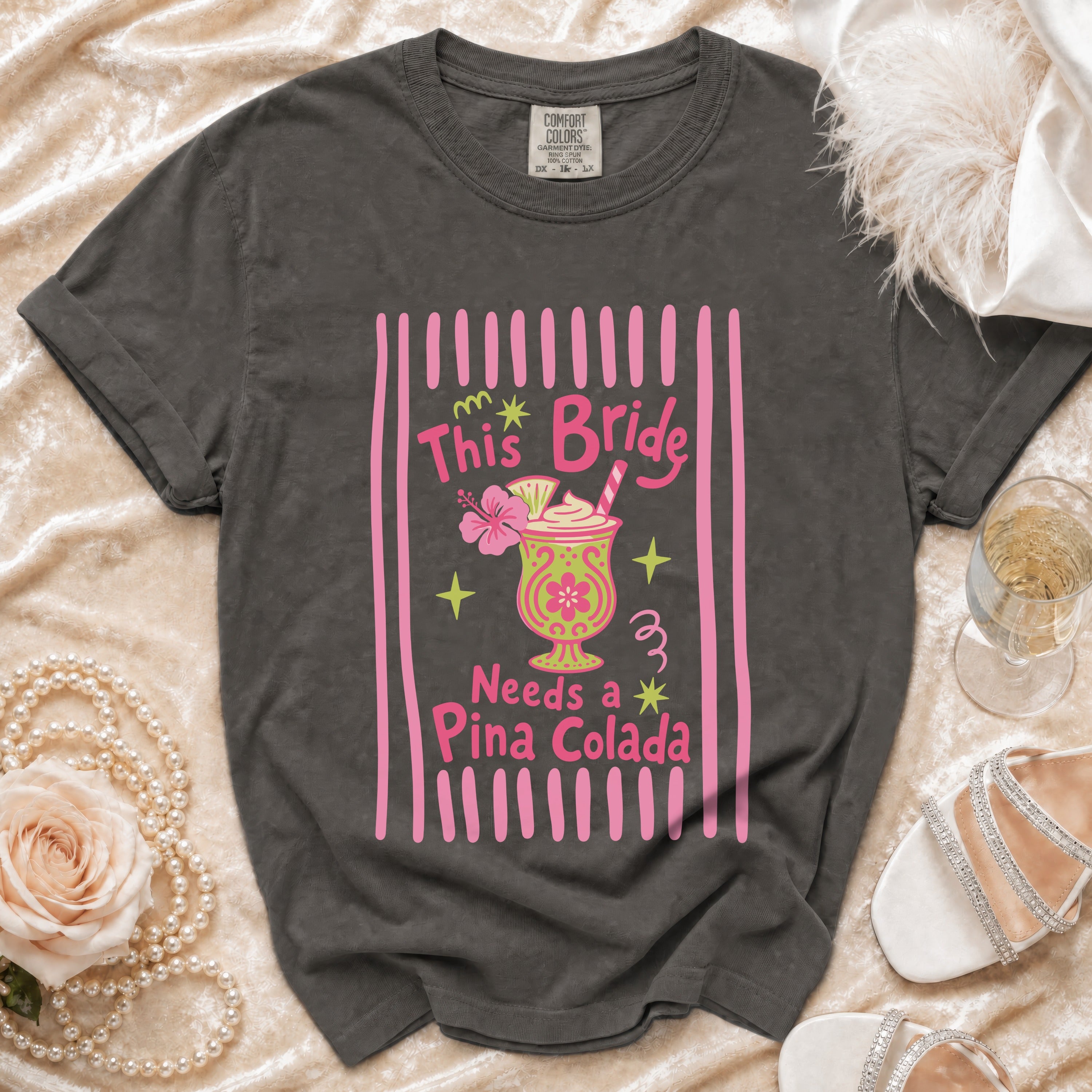 Dark grey t-shirt with "This Bride Needs a Pina Colada" graphic and a tropical drink.