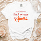 White t-shirt with "SPRITZ SOCIAL CLUB This Bride needs a Spritz" text in red and orange.