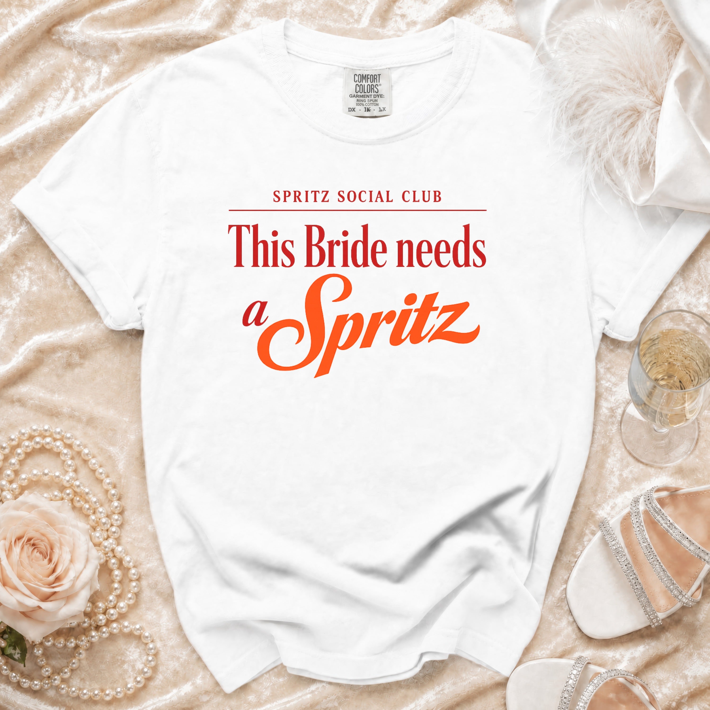 White t-shirt with "SPRITZ SOCIAL CLUB This Bride needs a Spritz" text in red and orange.