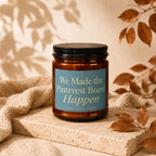 Amber jar candle with blue label reading "We Made the Pinterest Board Happen".
