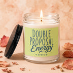 Jar candle with lit wick, showing a lime green label with text "Double Proposal Energy Vowed".