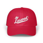 A bright red baseball cap embroidered with the white script word Lassoed across the front panel.