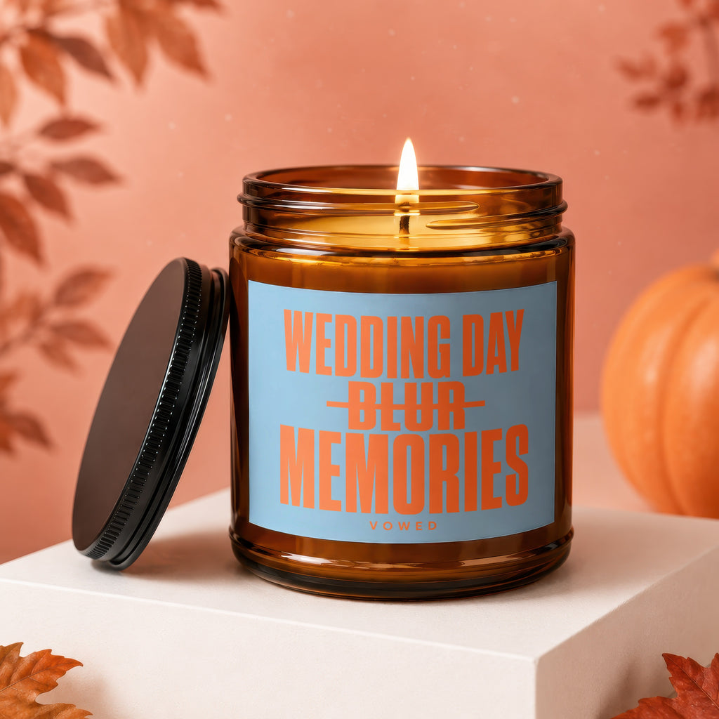 Amber candle with lit wick, black lid, and blue label reading "WEDDING DAY BLUR MEMORIES".