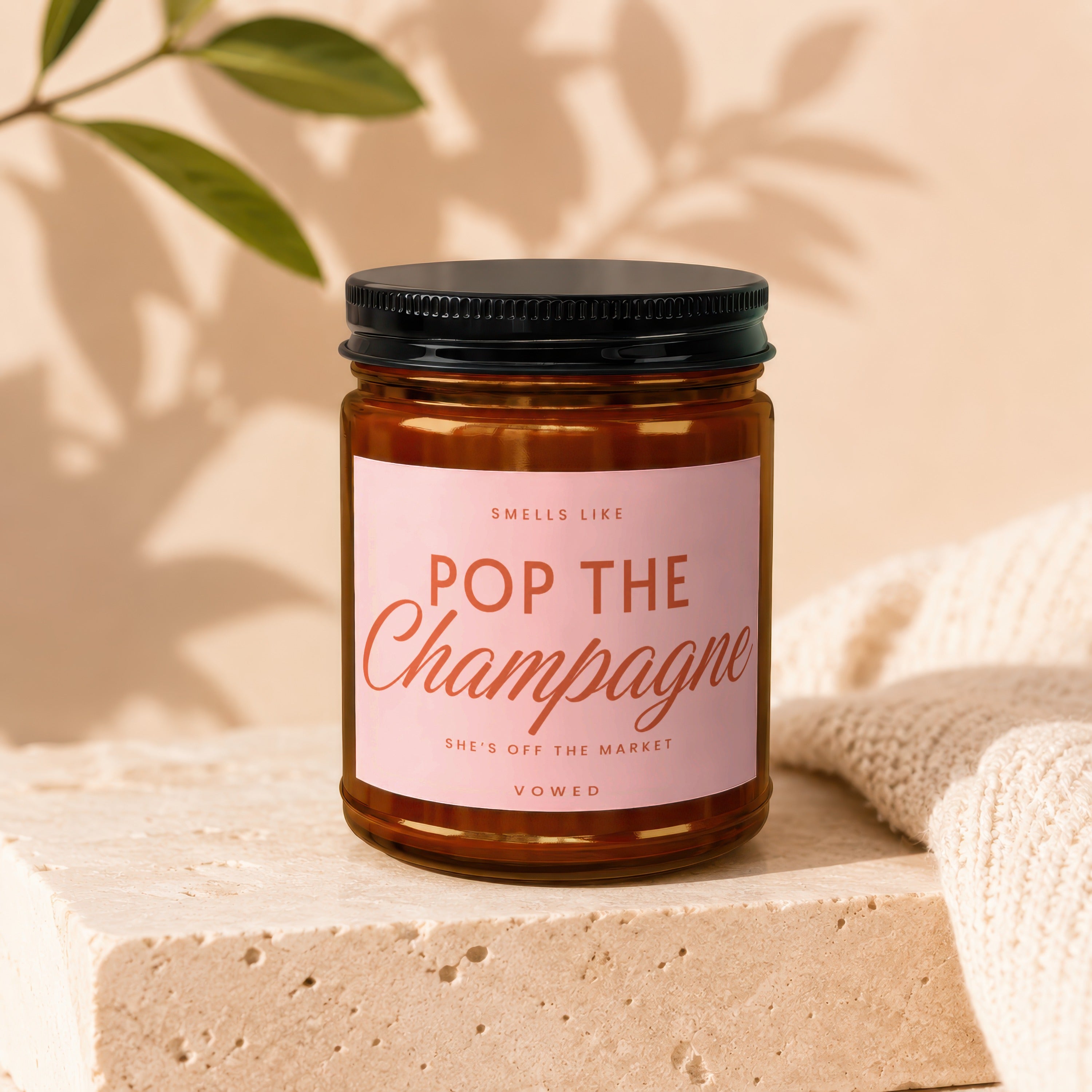 Candle labeled "Pop the Champagne" for sale from Vowed.